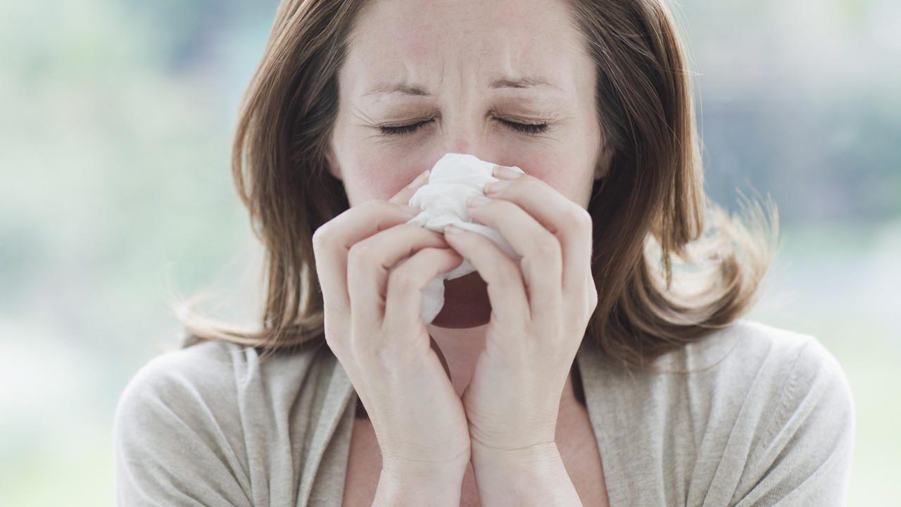 Sick woman wiping her nose